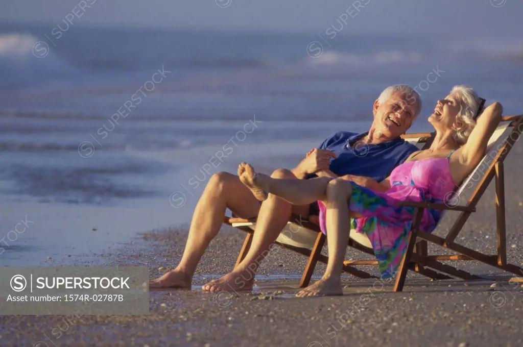 Senior couple sitting in deck chairs on the beach