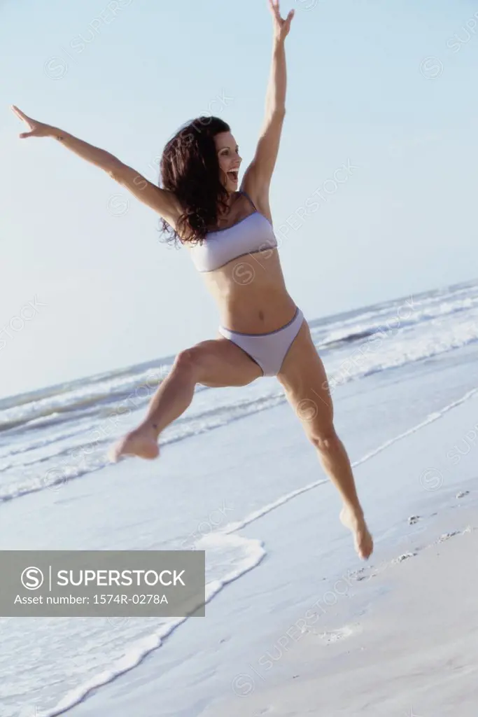 Young woman jumping at the beach