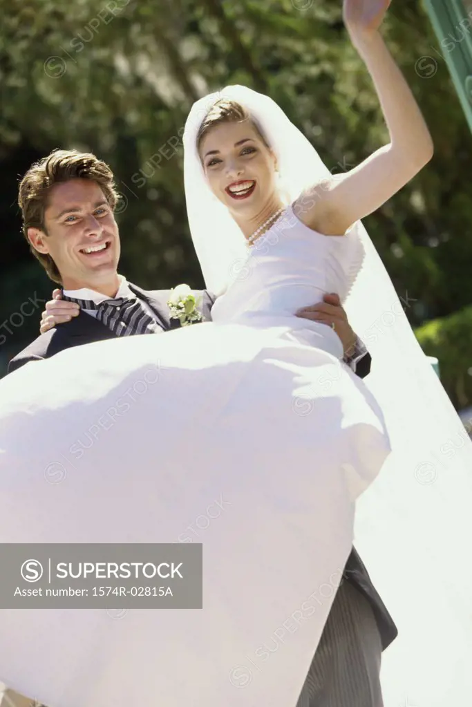 Portrait of a groom lifting his bride