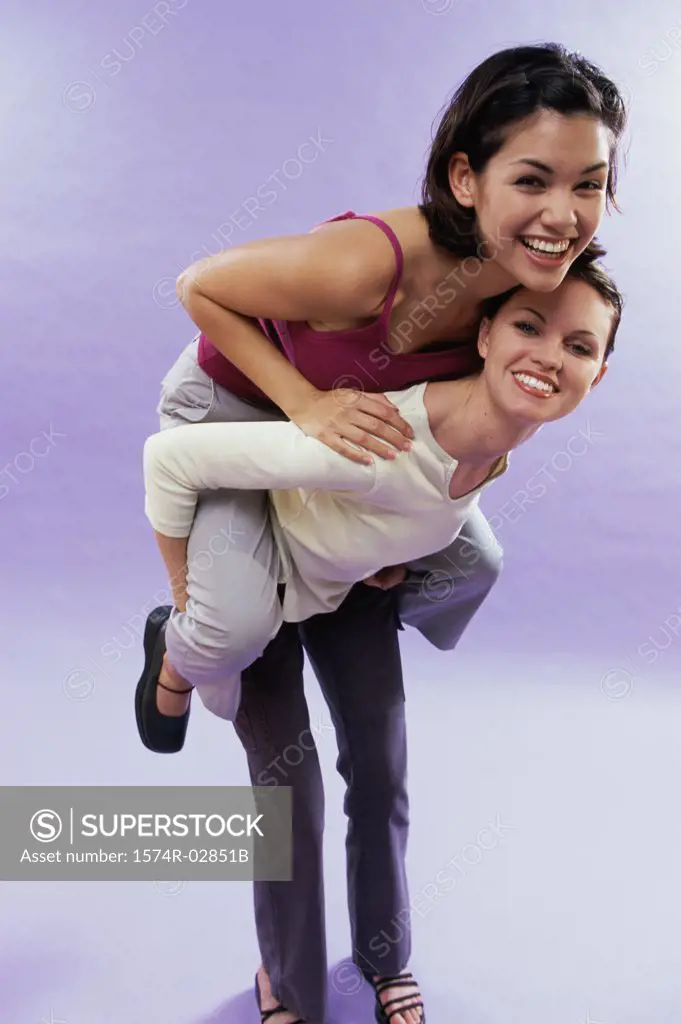 Portrait of a young woman riding piggyback on her friend