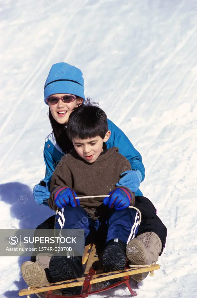 Boy and a girl riding a sled