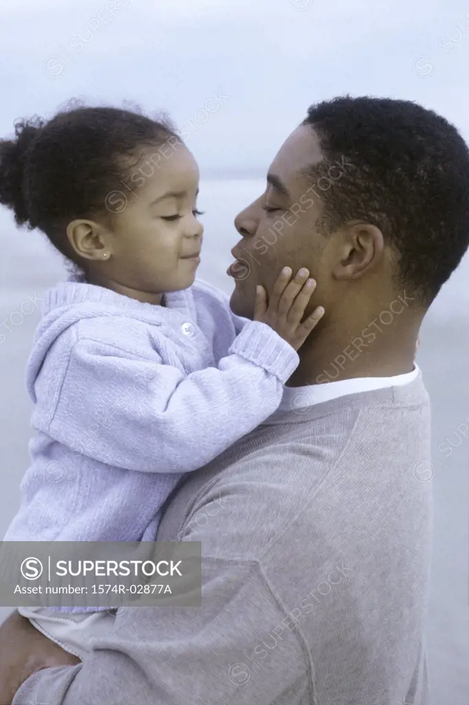 Side profile of a father holding his daughter