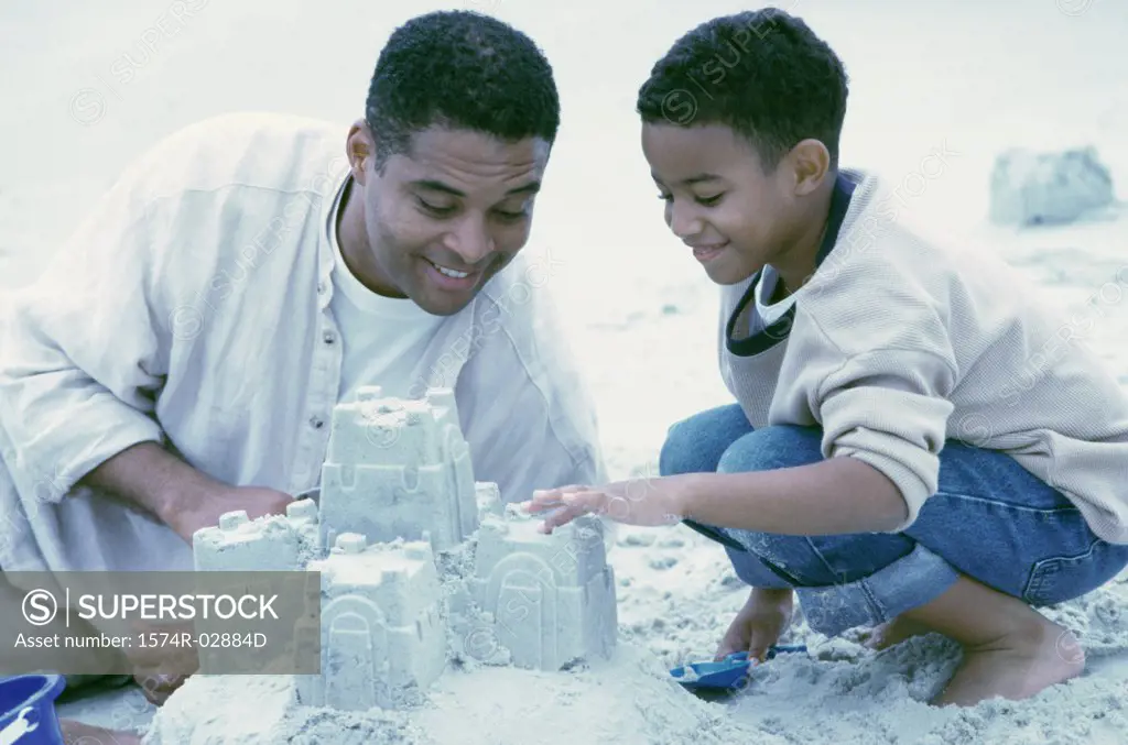 Father and his son building sand castles on the beach