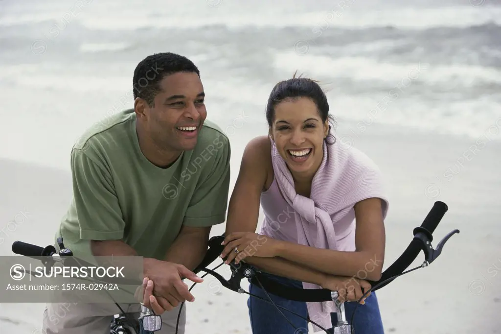 Young couple with bicycles on the beach