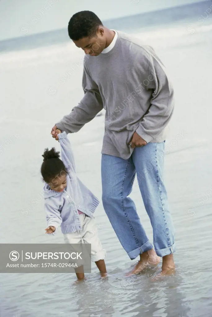Father walking with his daughter on the beach
