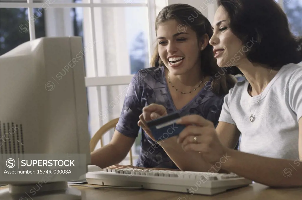 Mother and her daughter sitting in front of a computer