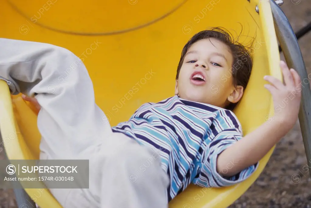 Portrait of a boy lying on a slide