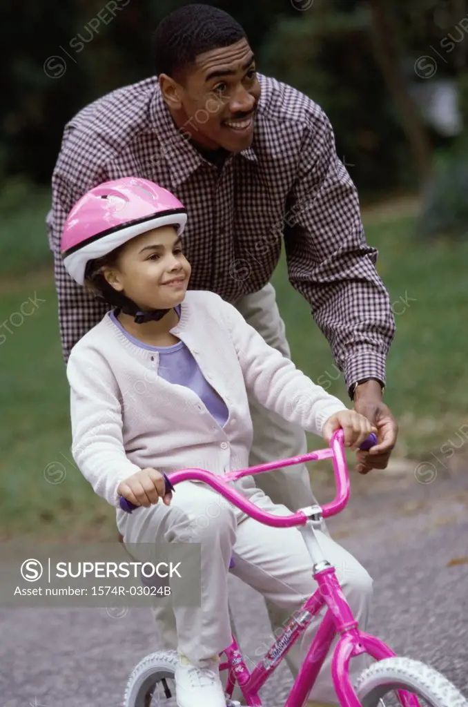 Father teaching his daughter cycling