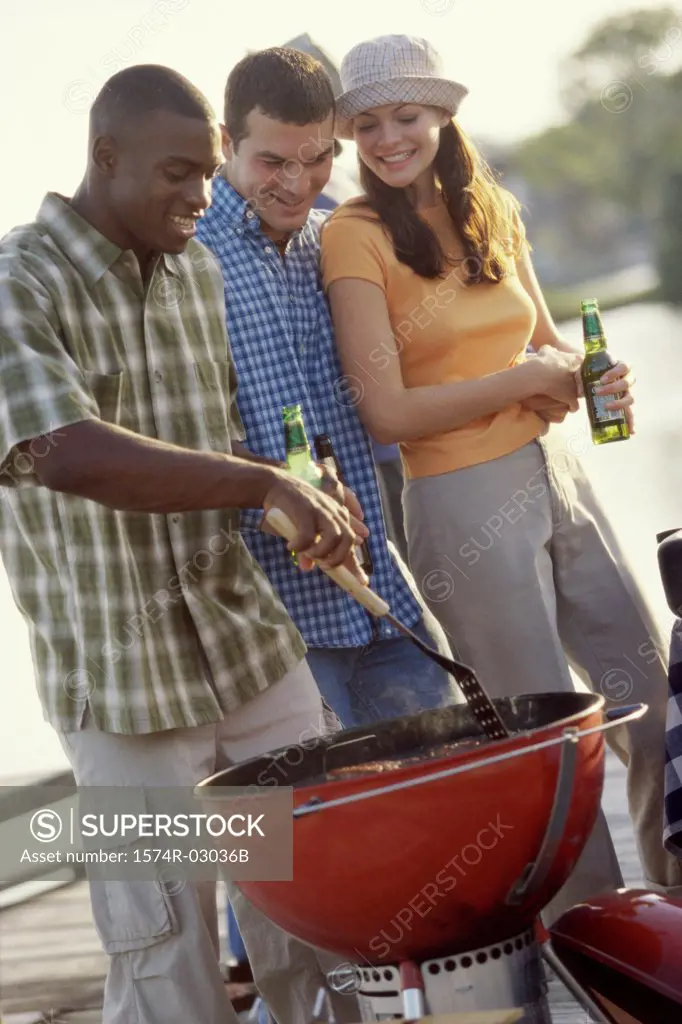 Two young men and a young woman at a barbecue