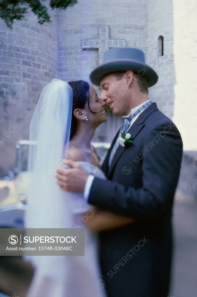 Side profile of a newlywed couple kissing each other