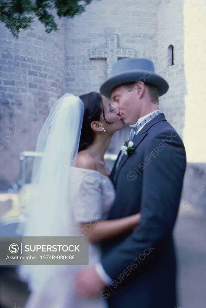 Side profile of a newlywed couple kissing each other