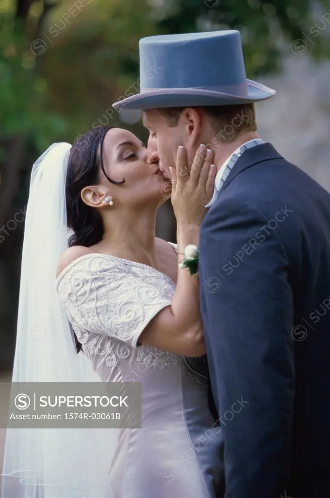 Newlywed couple kissing each other