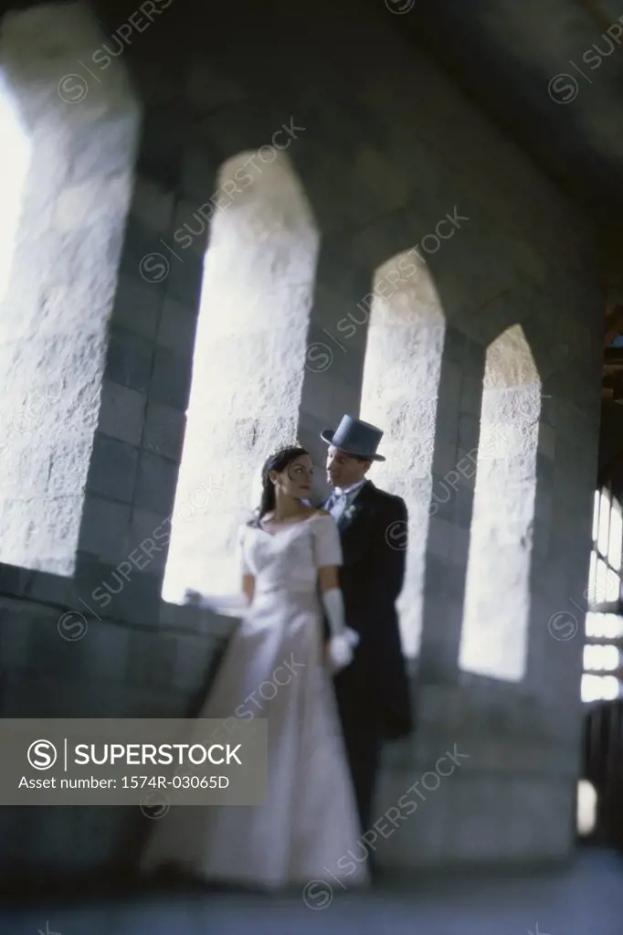 Newlywed couple standing in a castle