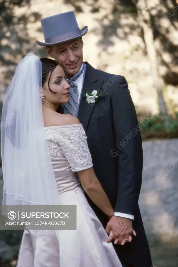 Newlywed couple standing holding hands