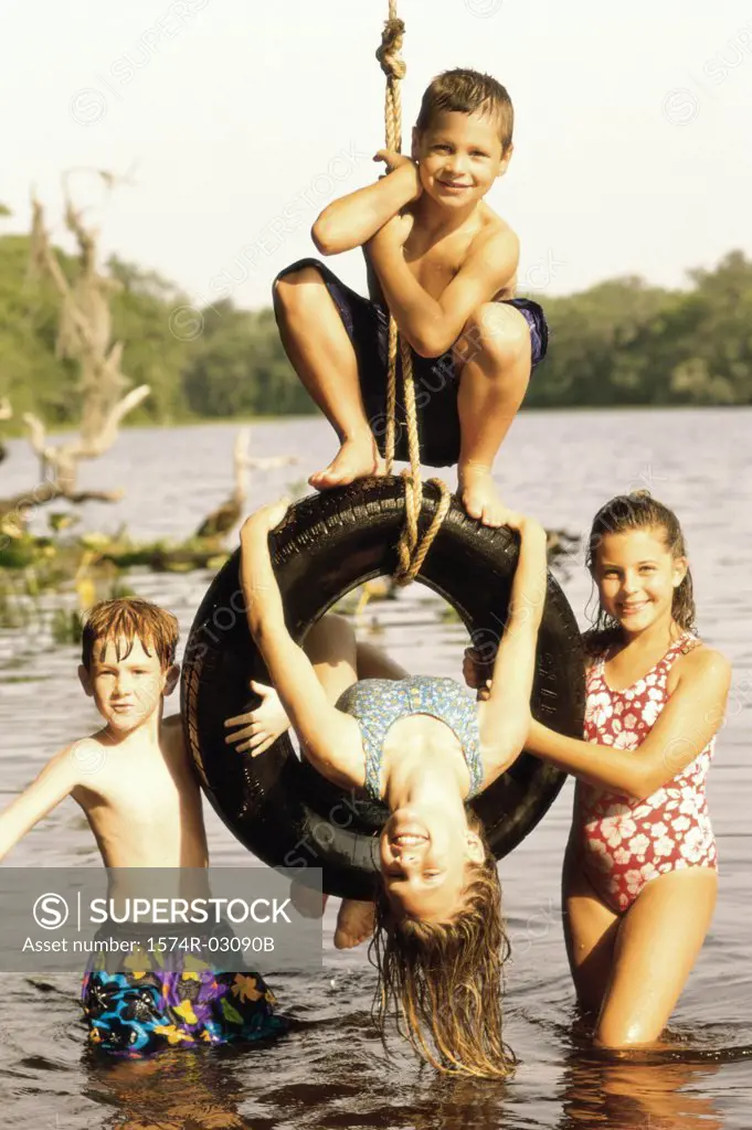 Portrait of a group of children playing on a tire swing