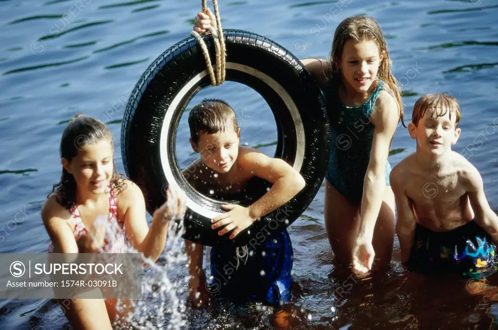 Group of children playing on a tire swing