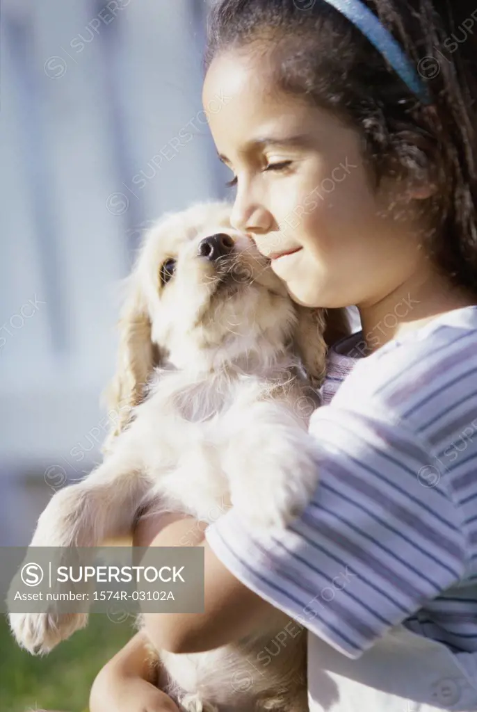 Side profile of a girl holding her puppy