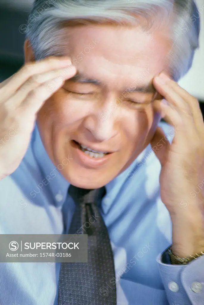 Close-up of a businessman holding his head
