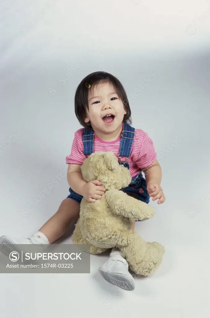 Baby girl playing with a teddy bear