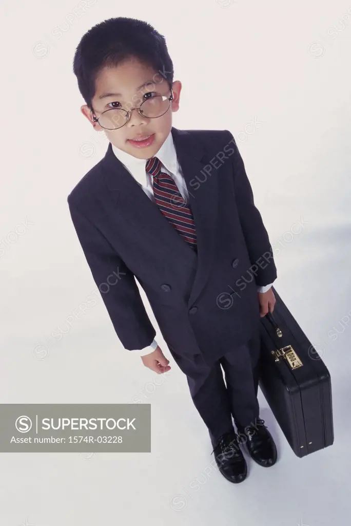 Portrait of a boy dressed as a businessman holding a briefcase