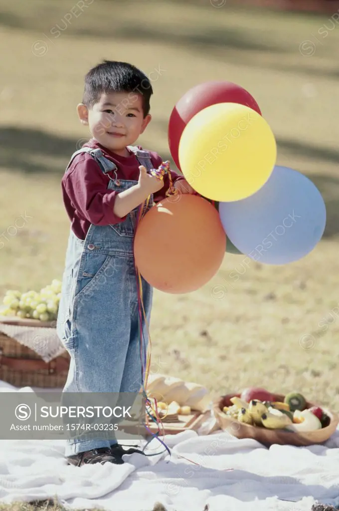 Portrait of a boy holding balloons