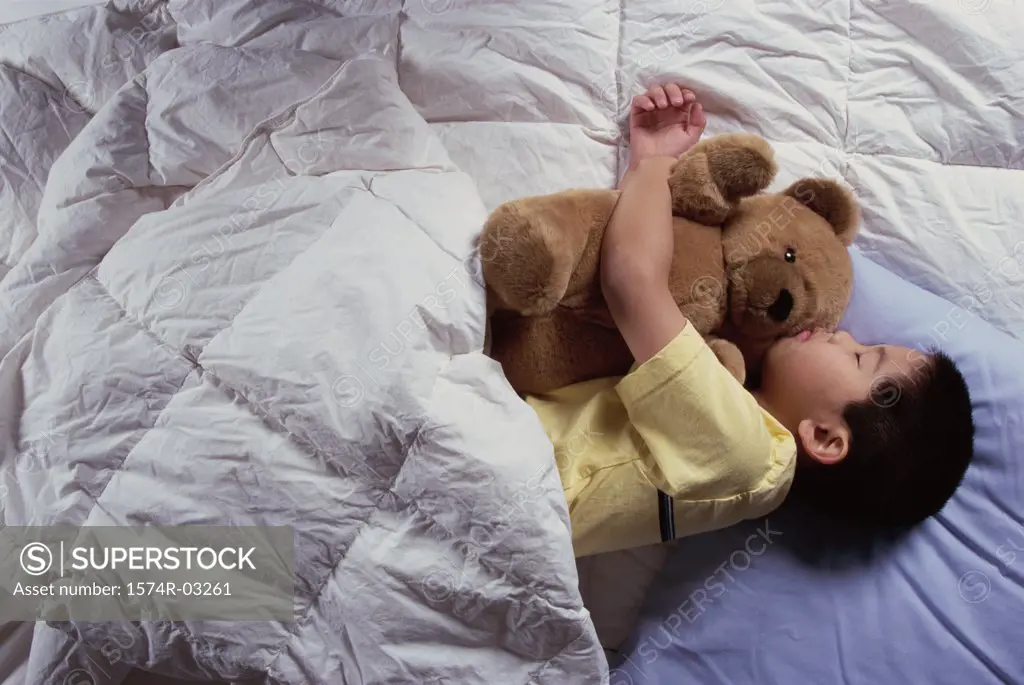 Boy sleeping with a teddy bear