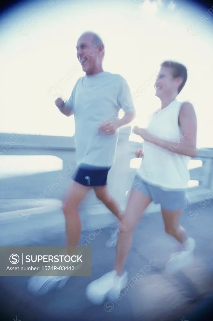 Senior couple jogging on a bridge