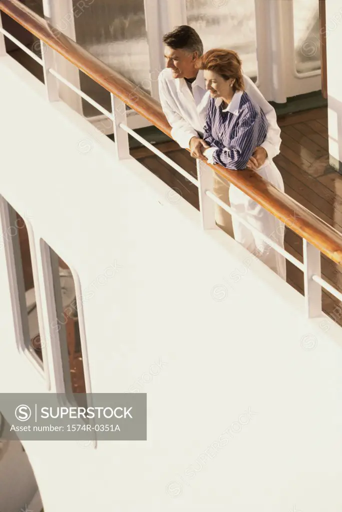Couple standing against the railing of a ship