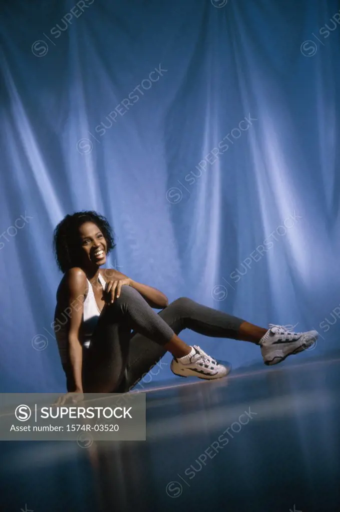 Young woman smiling sitting on the floor