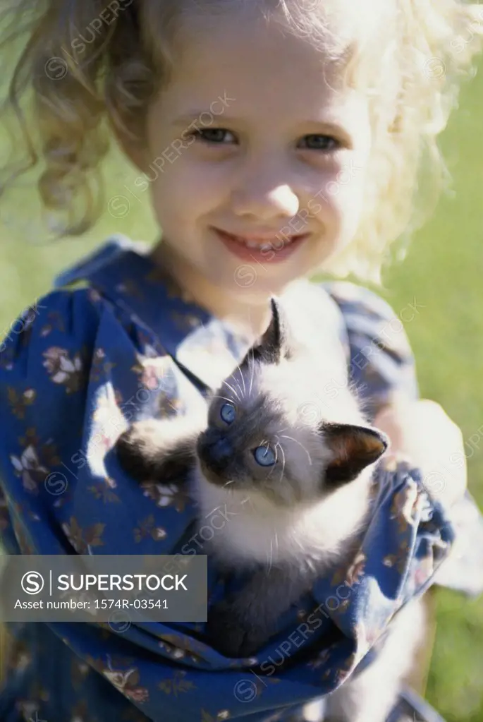 Portrait of a girl holding a Siamese kitten