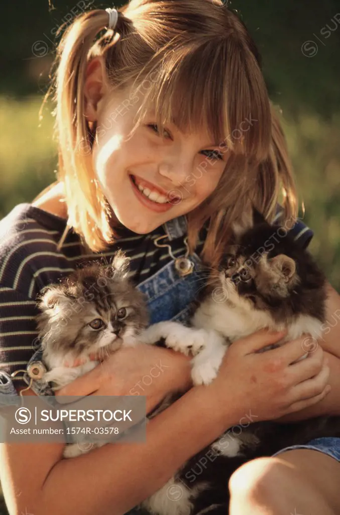 Portrait of a girl holding cats