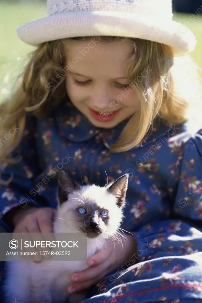 Close-up of a girl holding a Siamese kitten