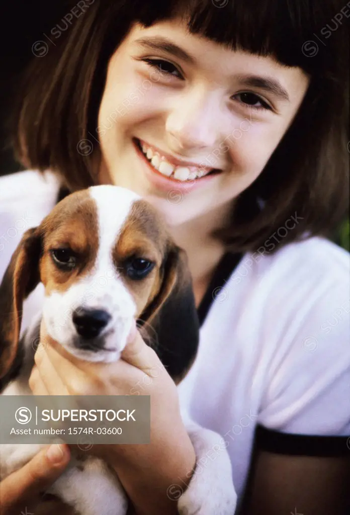 Portrait of a girl holding her puppy
