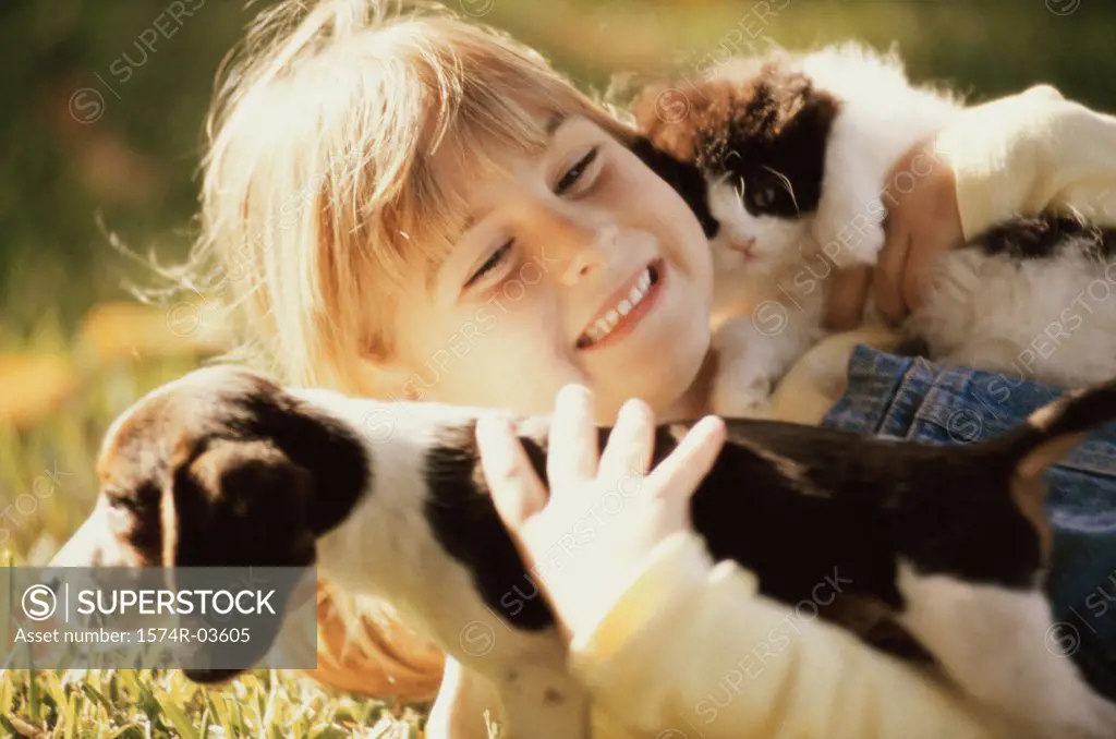 Close-up of a girl holding a puppy and a kitten