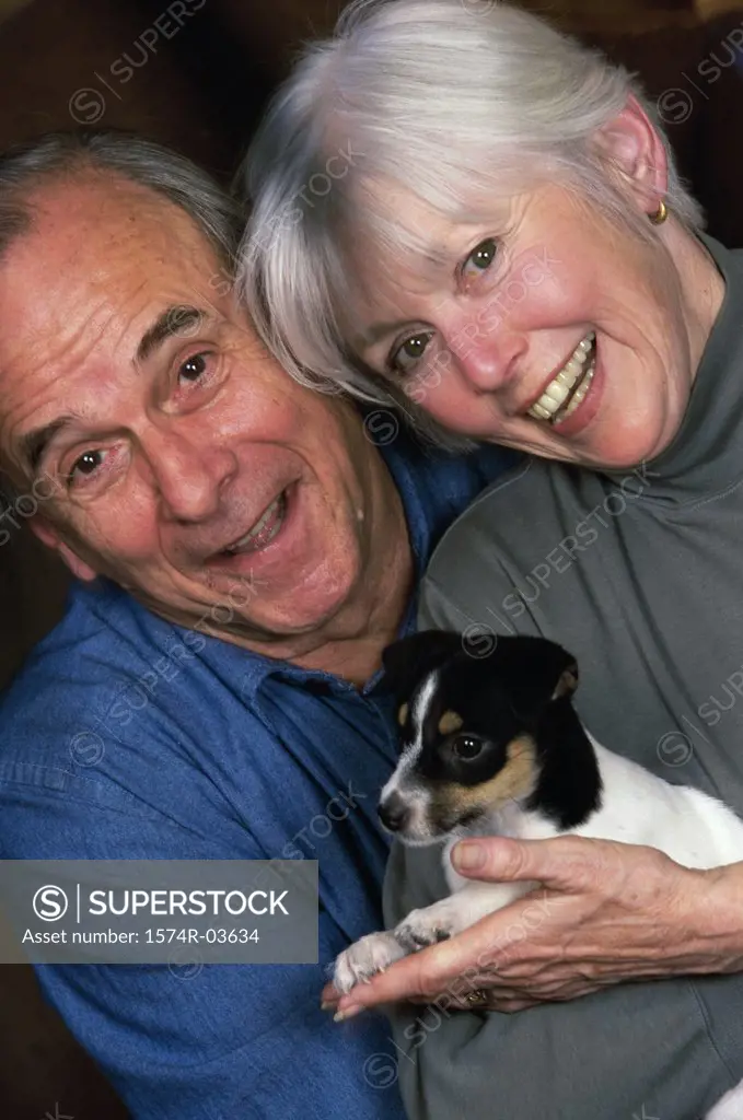 Portrait of a senior couple holding a puppy