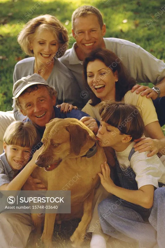 Portrait of a family sitting together on a lawn with their dog