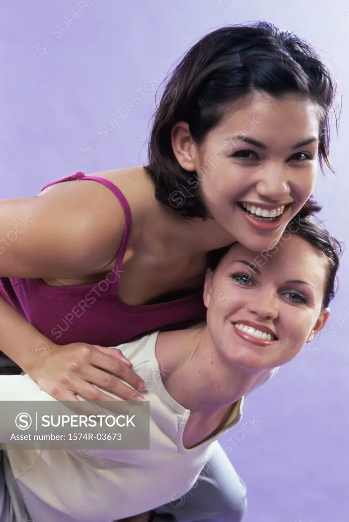 Portrait of a young woman riding piggyback on her friend