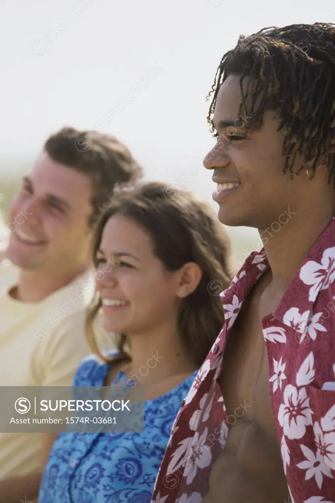 Side profile of two teenage boys and a teenage girl smiling