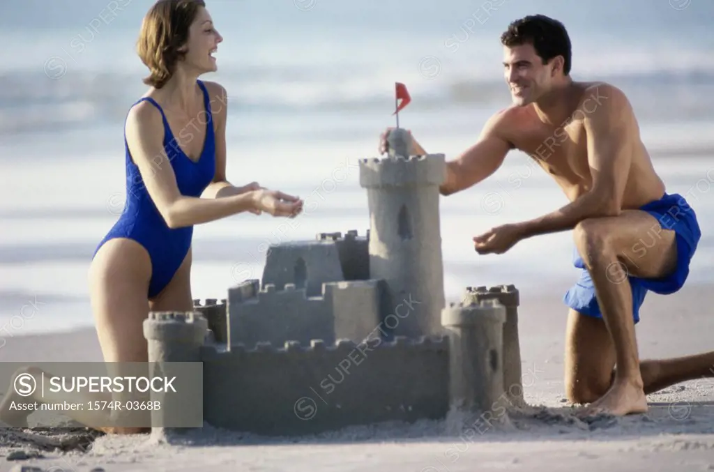 Young couple building a sandcastle on the beach