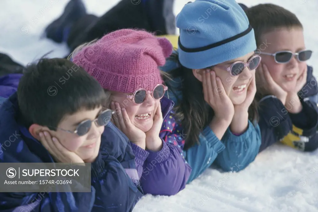 Close-up of a group of children lying in snow