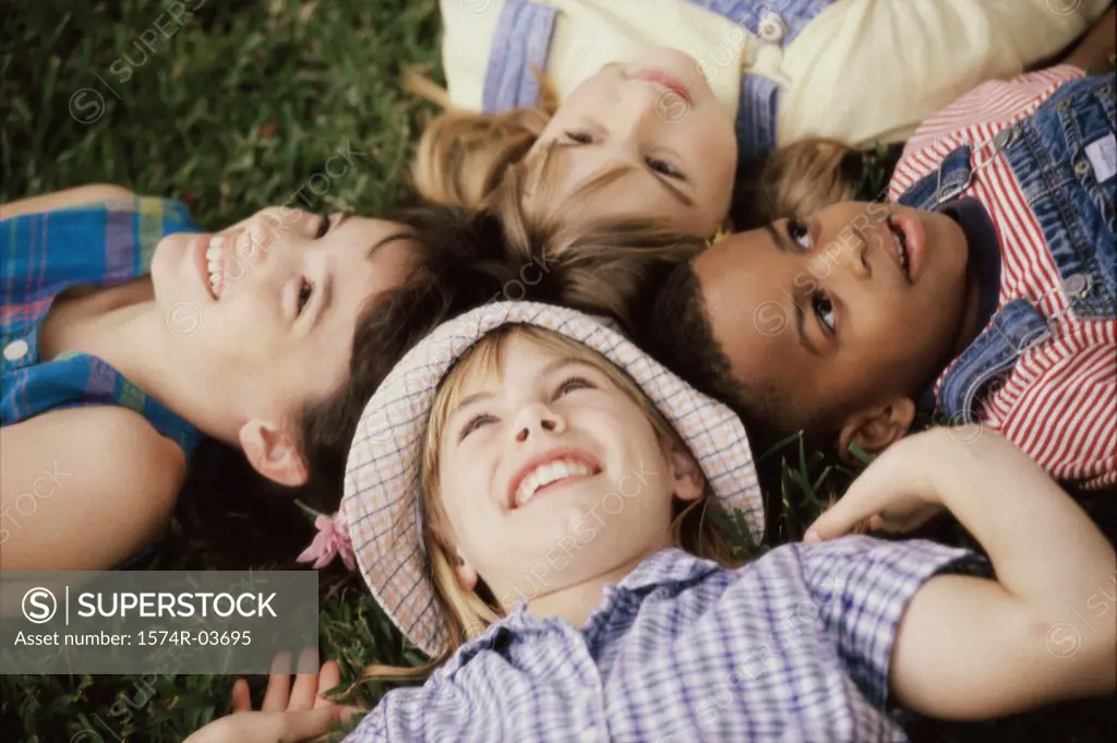 High angle view of a group of children lying on a lawn