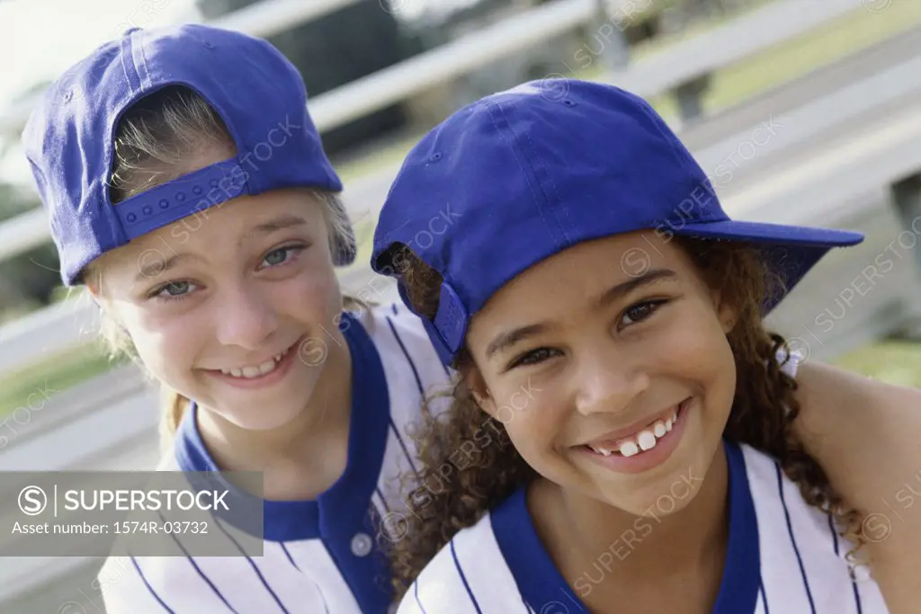 Portrait of two girls in baseball uniforms