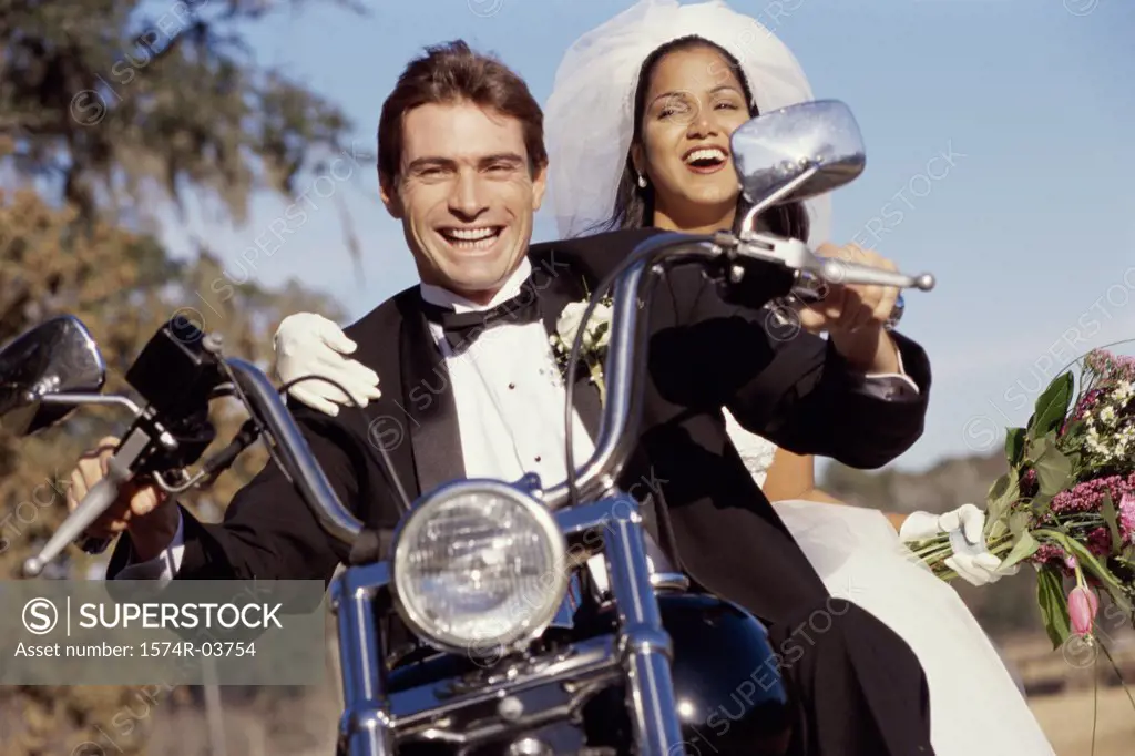 Portrait of a newlywed couple riding on a motorcycle