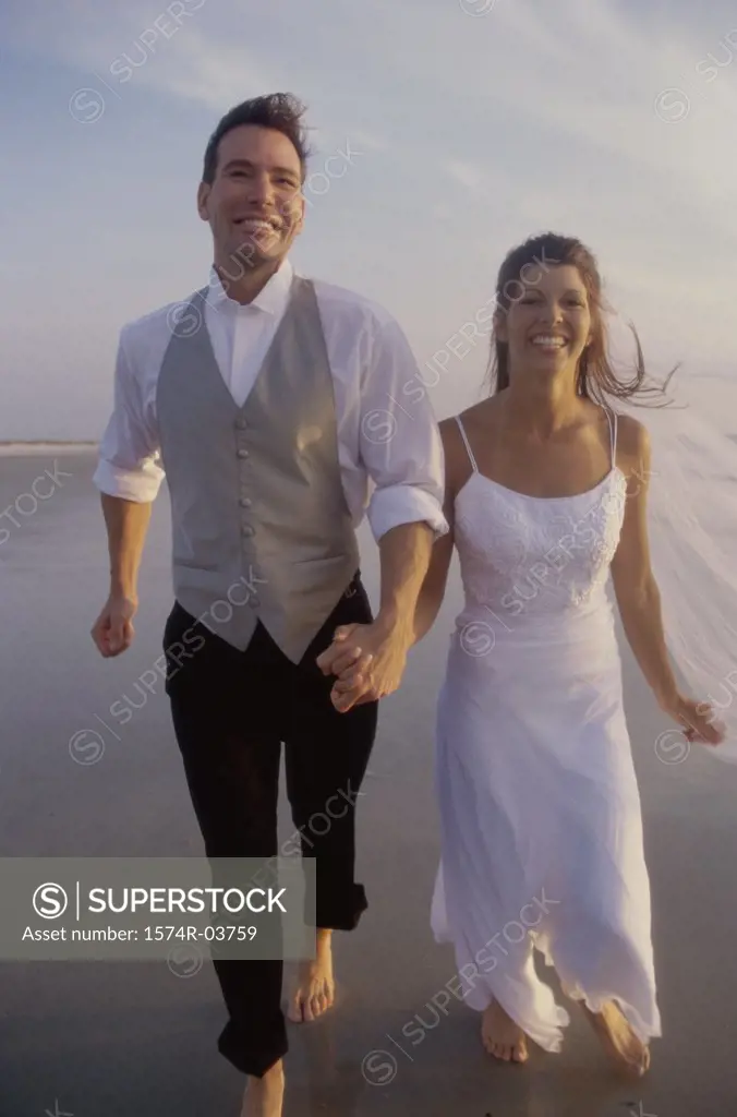 Newlywed couple walking on the beach