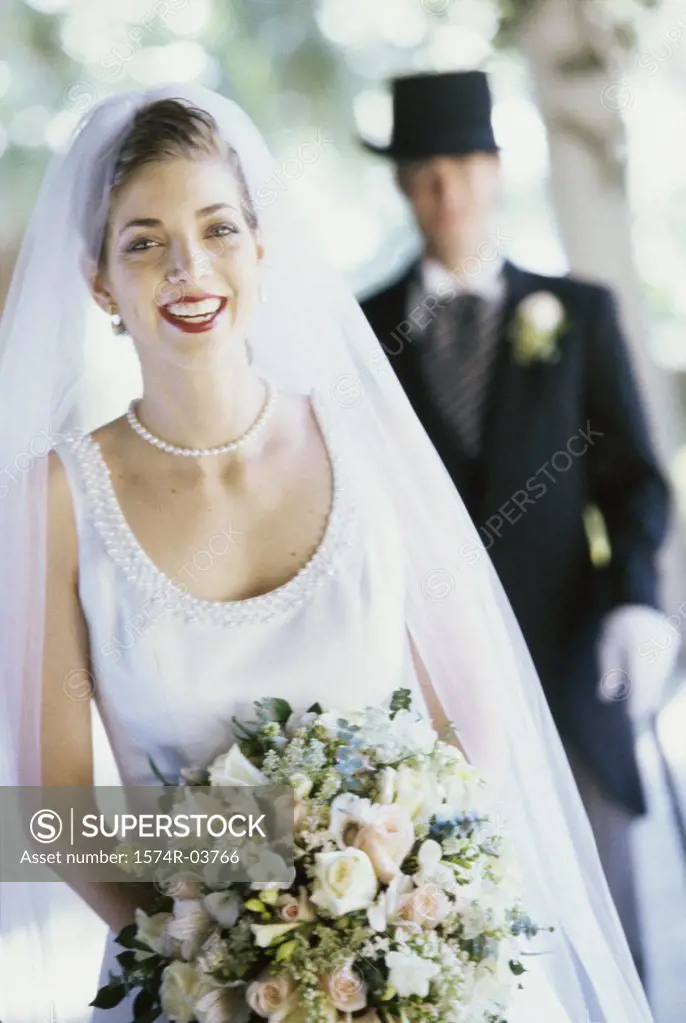 Portrait of a bride with her groom standing behind her