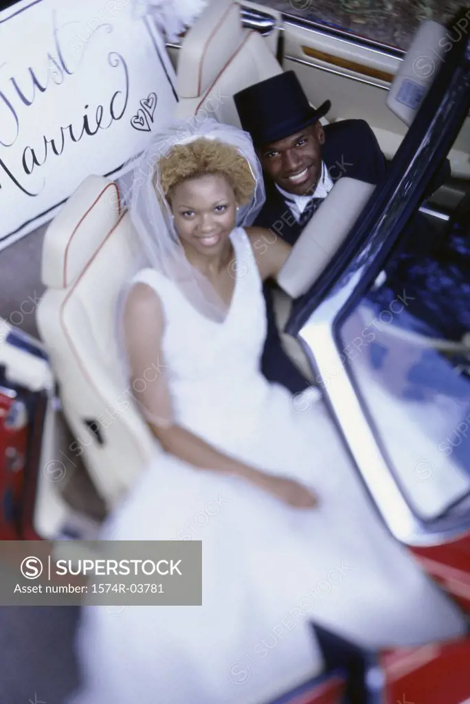 Portrait of a newlywed couple sitting in a convertible car
