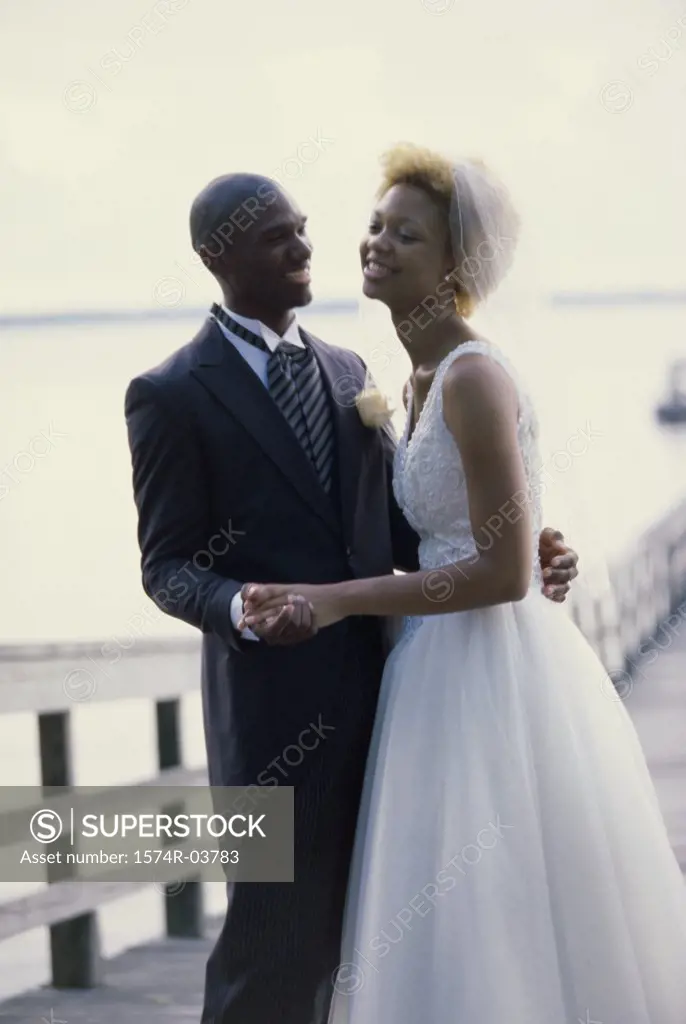 Newlywed couple embracing on a pier