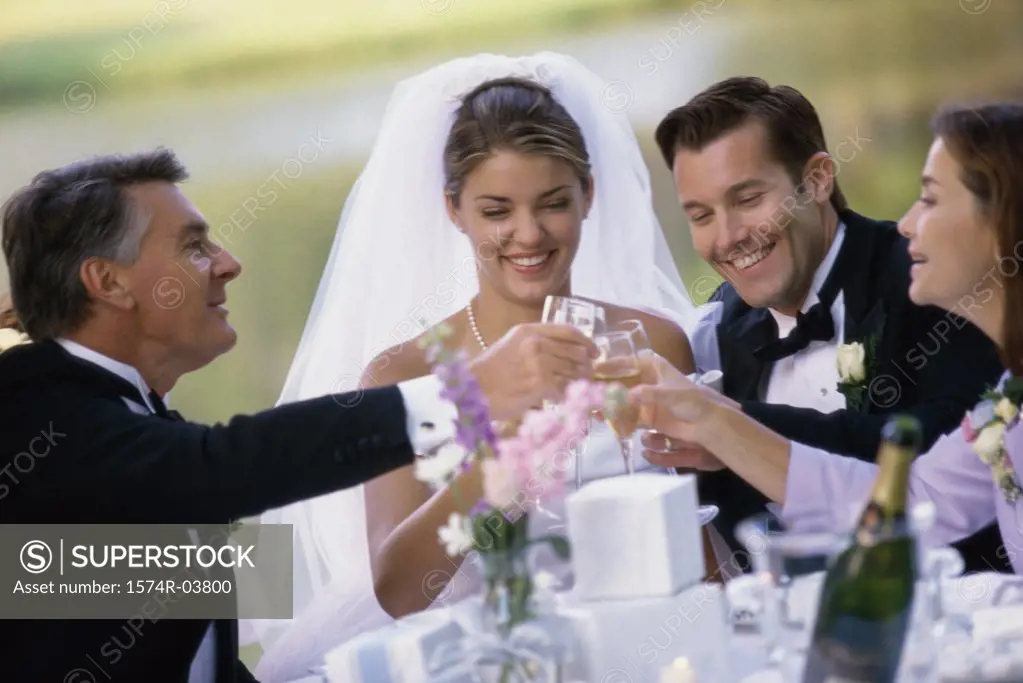 Newlywed couple toasting with their parents