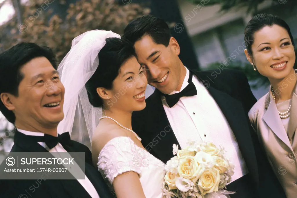 Newlywed couple smiling with their parents