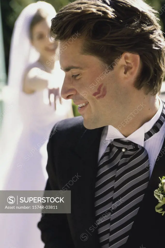 Close-up of a groom with lipstick marks on his cheek